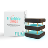 Image shows single Friendship Lamps with a packaging box. The lamps have a mini mid-century kona modern design with knotty alder wood and brushed aluminum details.