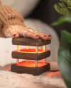 single mini mid century kona friendship lamp being touched to light up orange for connection of long distance relationships
