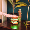 single mini mid century natural friendship lamp being touched and lighting up a green glow to connect to loved ones
